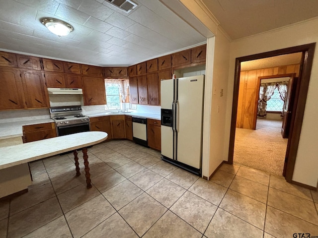 kitchen featuring white appliances, sink, light tile patterned floors, and ornamental molding