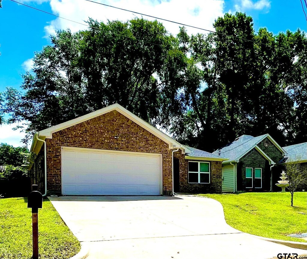 641 Hays Ave, Mount Pleasant, TX 75455 - single story home with an attached garage, a front lawn, driveway, and brick siding