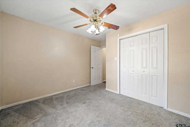 unfurnished bedroom with ceiling fan, carpet floors, a textured ceiling, and a closet