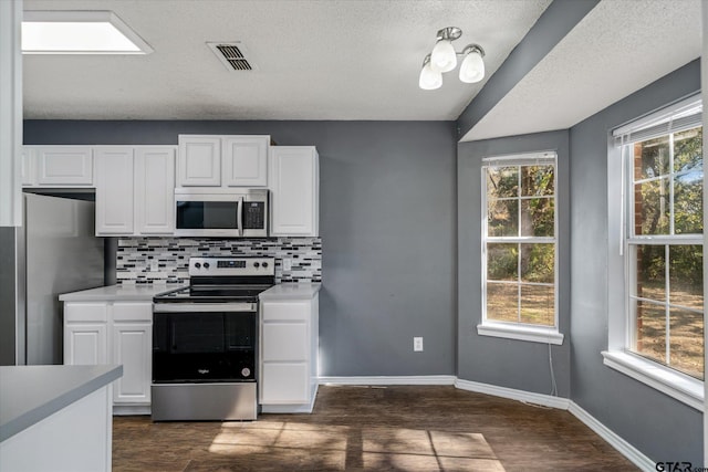 kitchen with decorative backsplash, dark hardwood / wood-style flooring, stainless steel appliances, and plenty of natural light