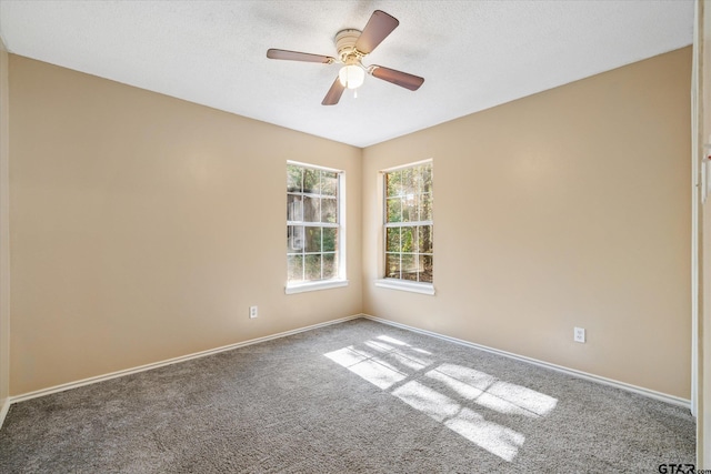 carpeted spare room featuring ceiling fan and a textured ceiling