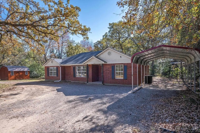 ranch-style house featuring a carport and a storage shed