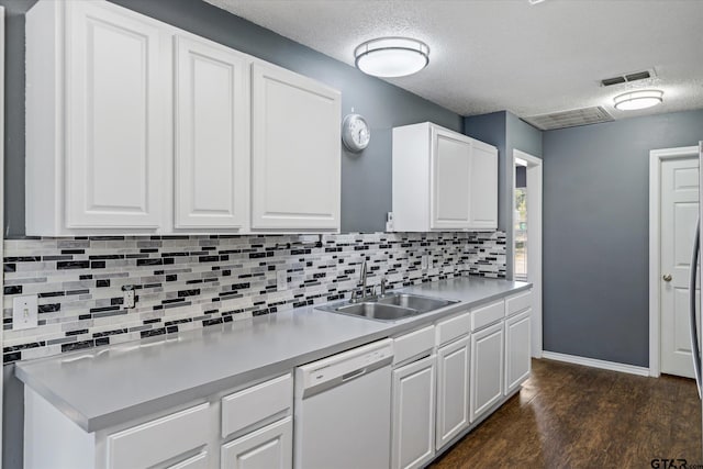 kitchen with white cabinets, white dishwasher, dark wood-type flooring, and sink