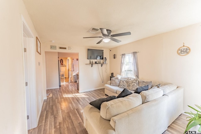 living room featuring hardwood / wood-style floors and ceiling fan