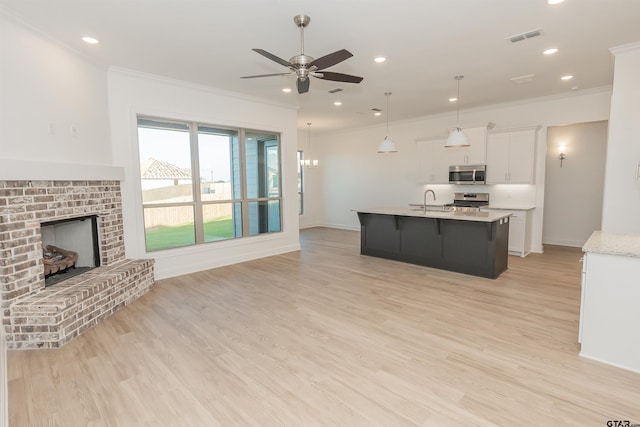 kitchen with appliances with stainless steel finishes, ornamental molding, a sink, and visible vents