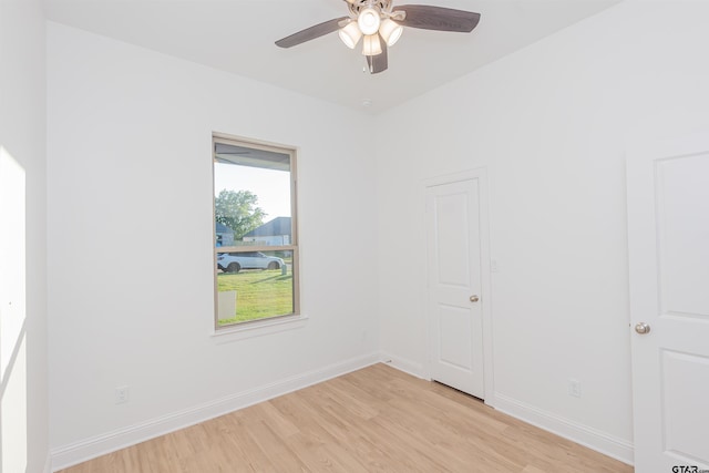 unfurnished room with ceiling fan, baseboards, and light wood-style floors
