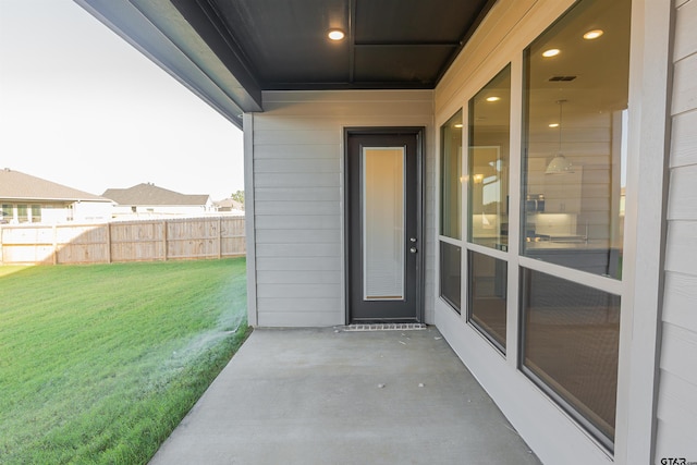 doorway to property featuring a yard, a patio, fence, and visible vents