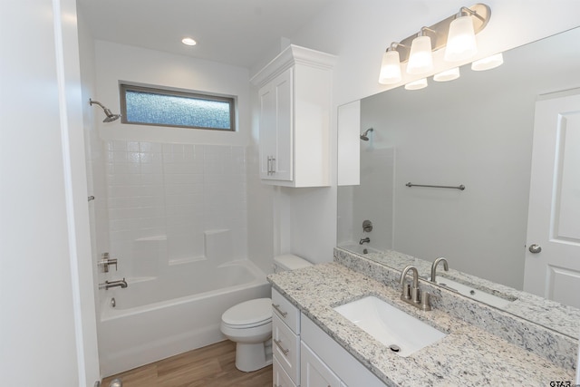 bathroom featuring vanity, toilet, wood finished floors, and bathtub / shower combination
