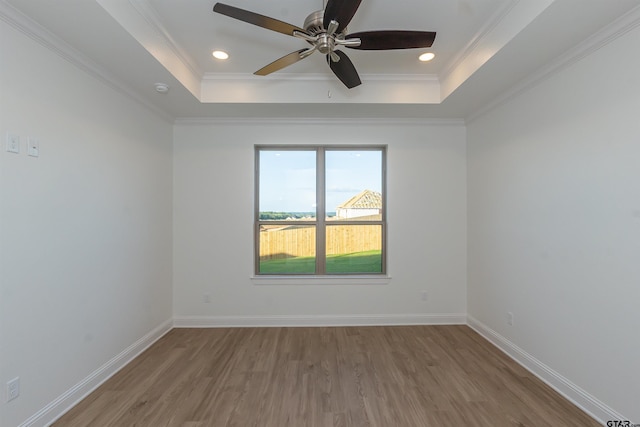 unfurnished room with a ceiling fan, a raised ceiling, and wood finished floors