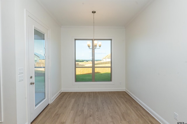 unfurnished dining area featuring light wood-type flooring, crown molding, a chandelier, and a wealth of natural light