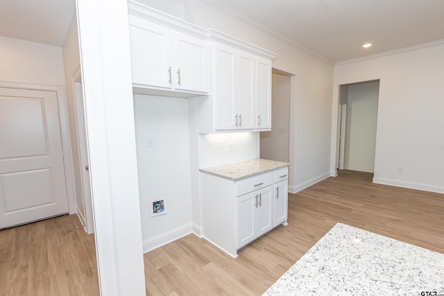kitchen with crown molding, light stone countertops, light wood-style floors, baseboards, and white cabinetry