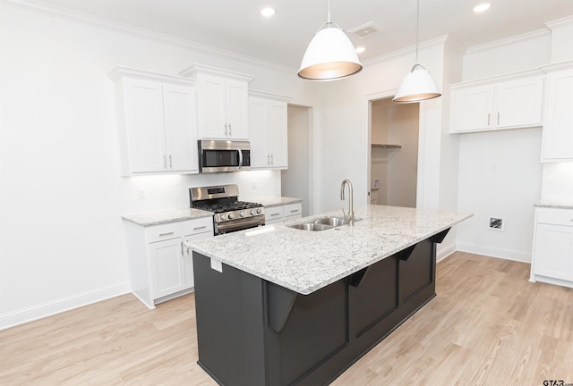 kitchen with a sink, decorative backsplash, appliances with stainless steel finishes, and white cabinetry