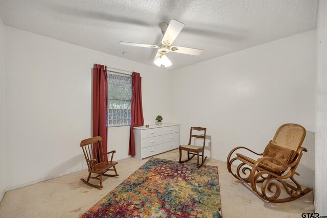 9961 Creek Bend Dr, Tyler, TX 75707 - living area with light colored carpet, a textured ceiling, and a ceiling fan