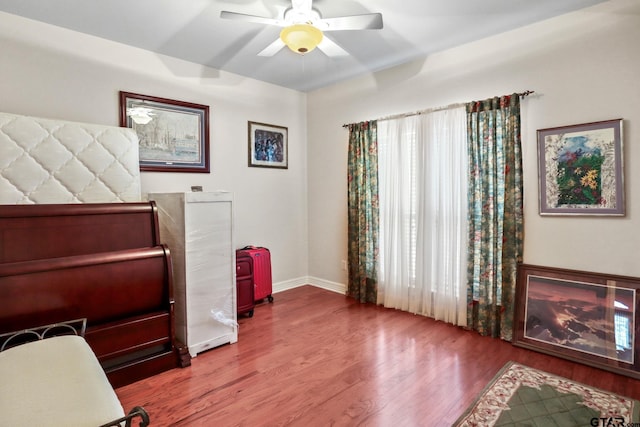 bedroom with ceiling fan, wood-type flooring, and multiple windows