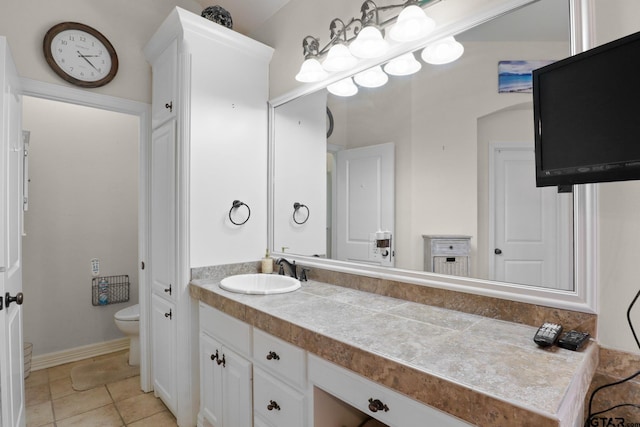 bathroom with tile patterned flooring, vanity, and toilet