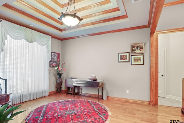 interior space with crown molding, wood-type flooring, and a tray ceiling