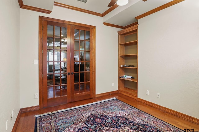 empty room with ornamental molding, ceiling fan, dark hardwood / wood-style flooring, and french doors