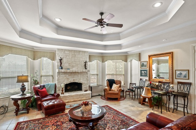 living room featuring a raised ceiling, light tile patterned floors, and a wealth of natural light