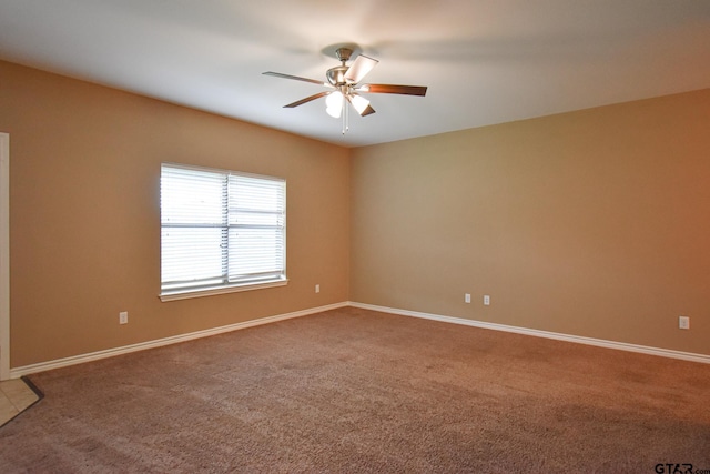 spare room featuring ceiling fan and carpet