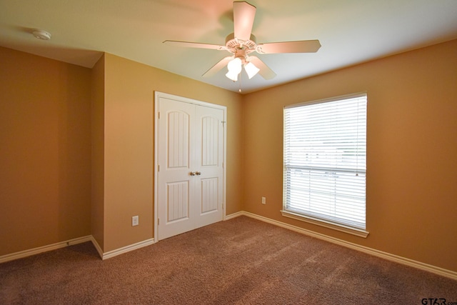 unfurnished bedroom with a closet, ceiling fan, and carpet floors