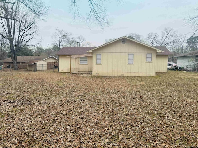 rear view of property featuring a lawn