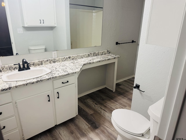 bathroom featuring vanity, hardwood / wood-style flooring, a shower, and toilet