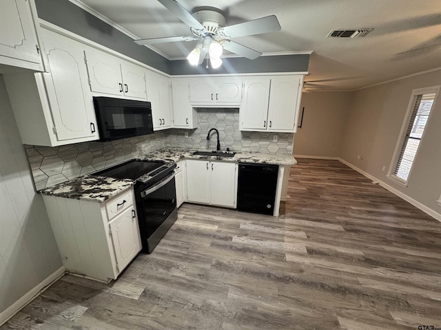 kitchen featuring sink, hardwood / wood-style flooring, white cabinetry, backsplash, and black appliances