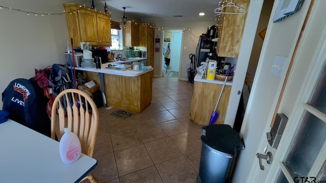 kitchen featuring dark tile patterned floors, sink, pendant lighting, and kitchen peninsula