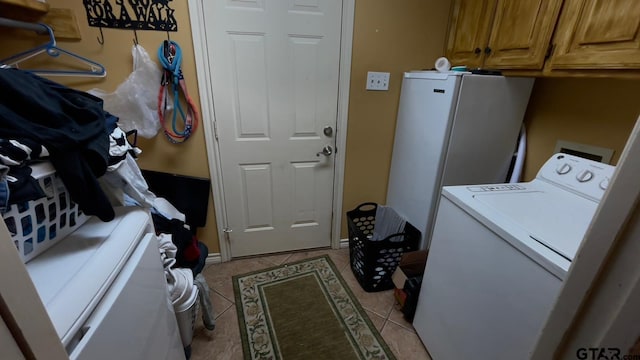 laundry area with cabinets, light tile patterned floors, and washer / clothes dryer