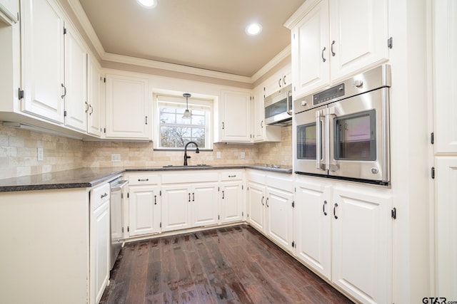 kitchen with white cabinets, dark hardwood / wood-style flooring, stainless steel appliances, tasteful backsplash, and sink