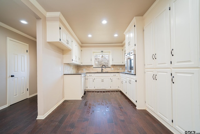 kitchen with white cabinets, backsplash, oven, and sink