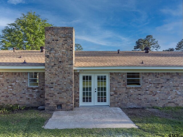 3803 Peavine Rd, Kilgore, TX 75662 - doorway to property featuring french doors, a chimney, a patio, a shingled roof, and brick siding