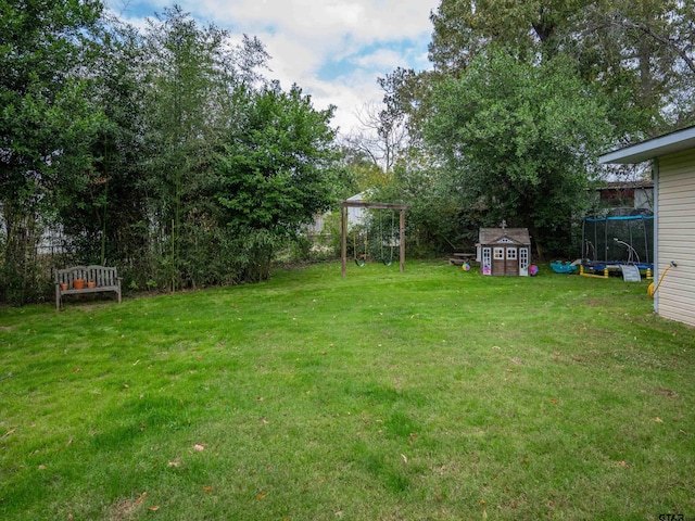 view of yard with a trampoline and a storage shed