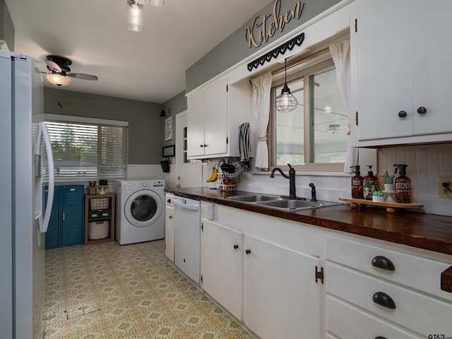 kitchen with sink, refrigerator, dishwasher, washer / clothes dryer, and white cabinets