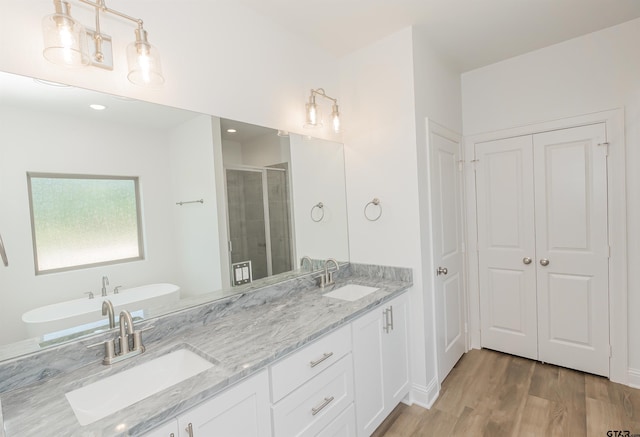 bathroom with hardwood / wood-style floors, vanity, and plus walk in shower