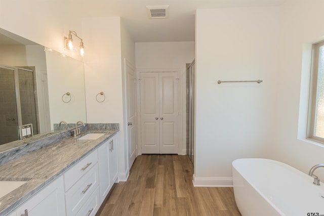 bathroom with wood-type flooring, separate shower and tub, and vanity