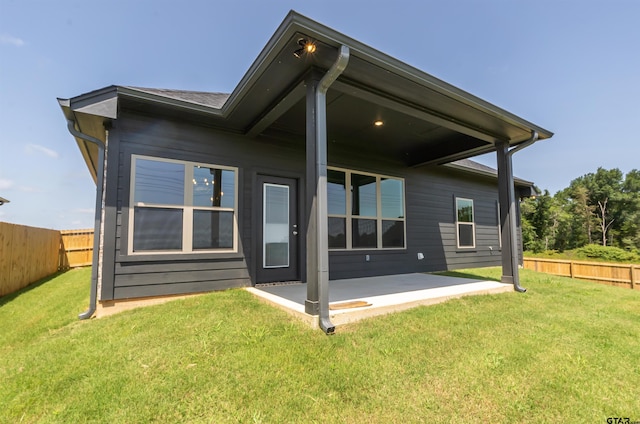 rear view of property with a yard and a patio