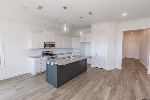 kitchen with stainless steel appliances, light stone countertops, an island with sink, light hardwood / wood-style floors, and white cabinets