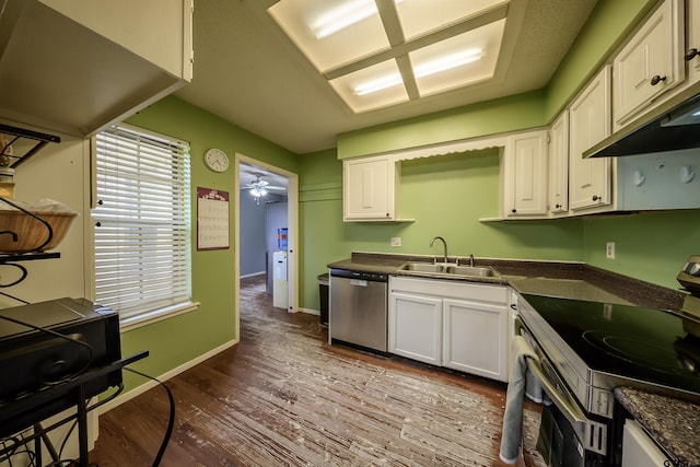17550 Kristopher Cir, Whitehouse, TX 75791 - kitchen featuring appliances with stainless steel finishes, dark countertops, under cabinet range hood, dark wood-type flooring, and white cabinetry