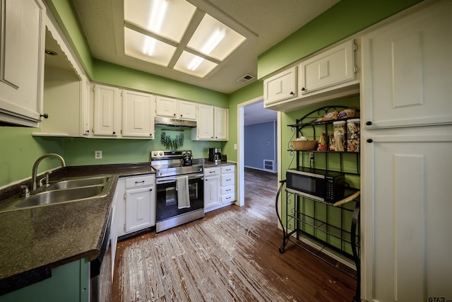17550 Kristopher Cir, Whitehouse, TX 75791 - kitchen with appliances with stainless steel finishes, under cabinet range hood, dark countertops, white cabinets, and dark wood finished floors