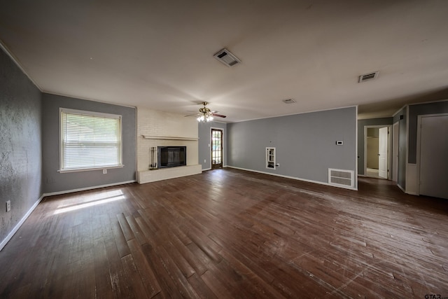 17550 Kristopher Cir, Whitehouse, TX 75791 - unfurnished living room featuring a ceiling fan, dark wood-style floors, a brick fireplace, and ornamental molding