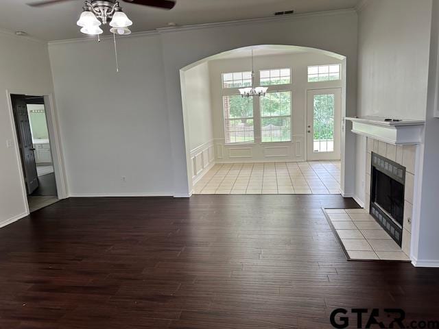 1712 Onyx Cv, Whitehouse, TX 75791 - unfurnished living room with wood finished floors, ornamental molding, a ceiling fan, a tiled fireplace, and a chandelier