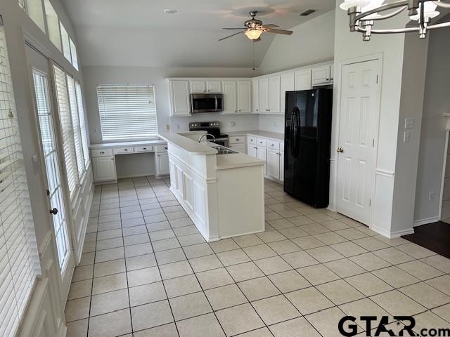 1712 Onyx Cv, Whitehouse, TX 75791 - kitchen with stainless steel appliances, vaulted ceiling, light tile patterned flooring, light countertops, and white cabinetry
