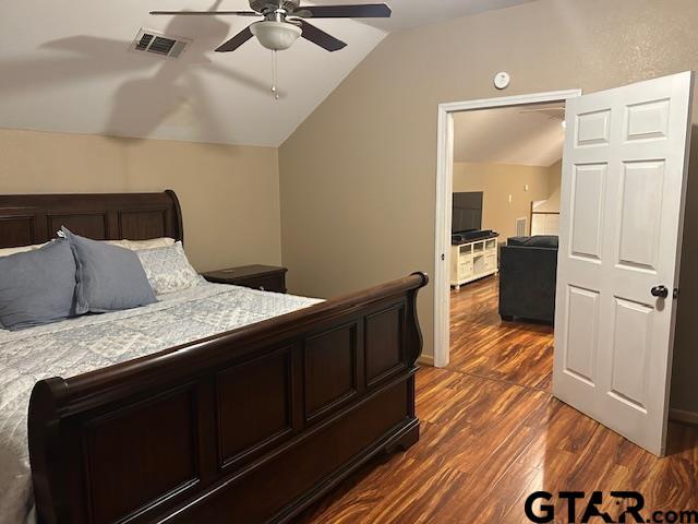 bedroom with ceiling fan, lofted ceiling, and dark hardwood / wood-style flooring