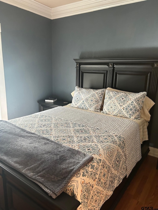 bedroom featuring dark hardwood / wood-style flooring and ornamental molding