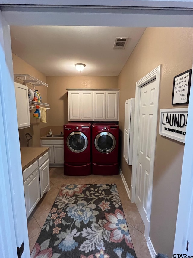 laundry room with cabinets, sink, washer and dryer, and light tile patterned floors