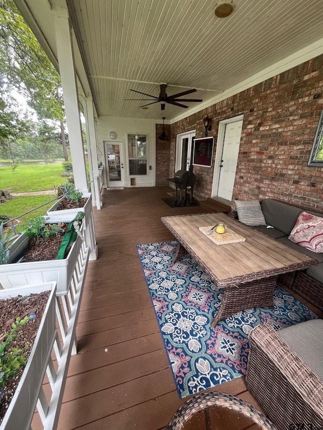 wooden deck with covered porch and ceiling fan