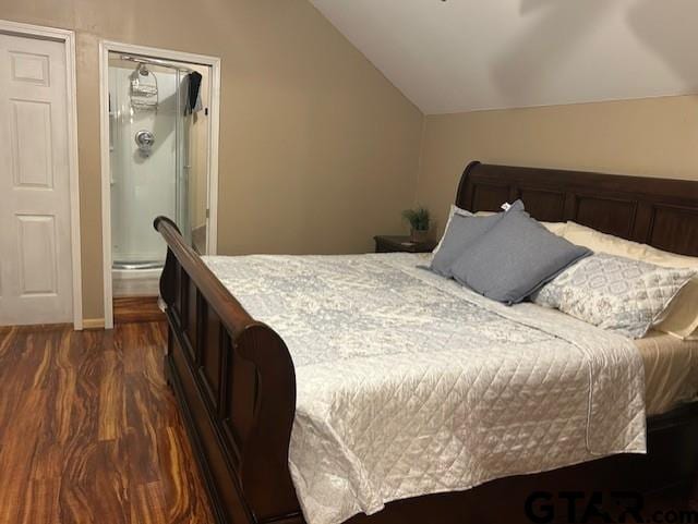 bedroom featuring dark hardwood / wood-style flooring, connected bathroom, and vaulted ceiling