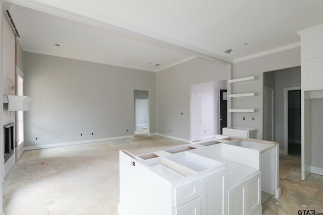 kitchen with a center island, white cabinetry, and ornamental molding