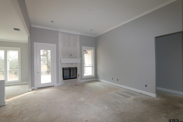 unfurnished living room with a wealth of natural light, a fireplace, and crown molding